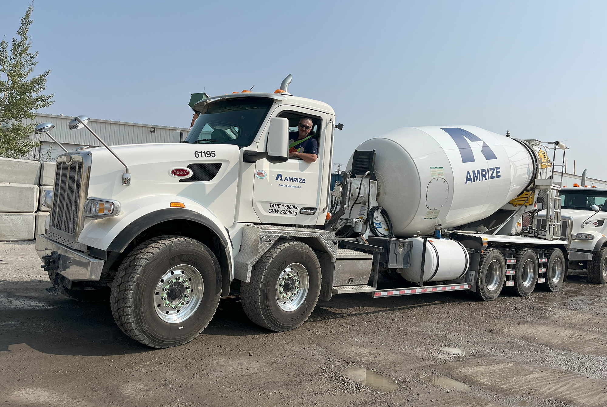 A large cement mixing truck in a parking lot under a blue sky
