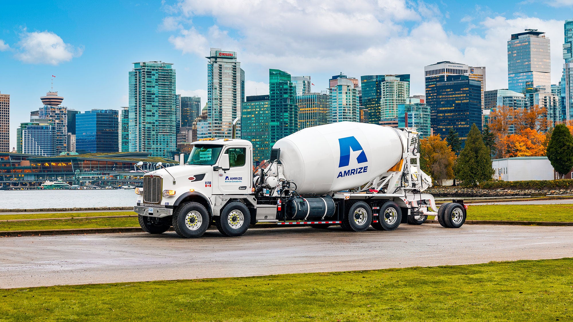 White Amrize Ready-mix concrete truck with the Vancouver city skyline in the background.