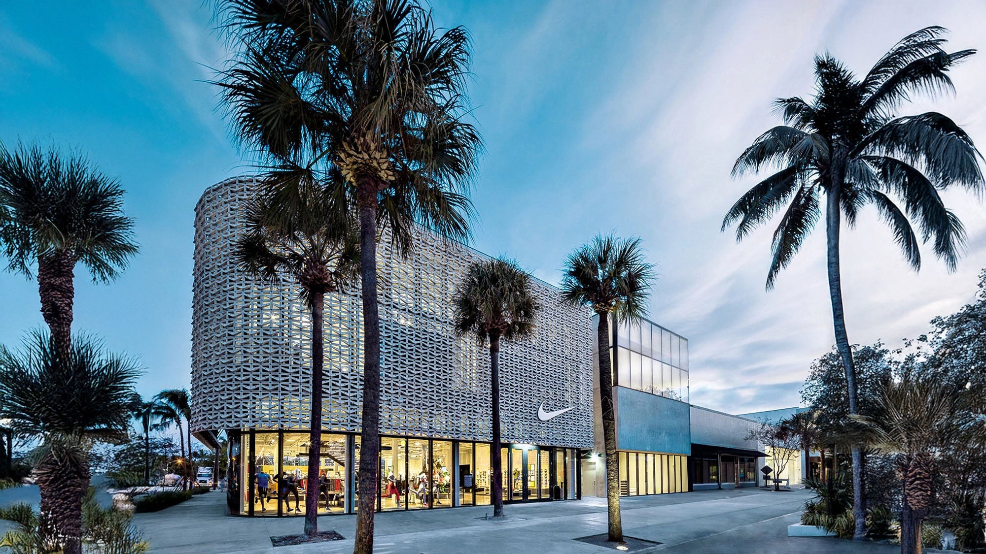 An intricate concrete facade on a retail storefront surrounded by palm trees