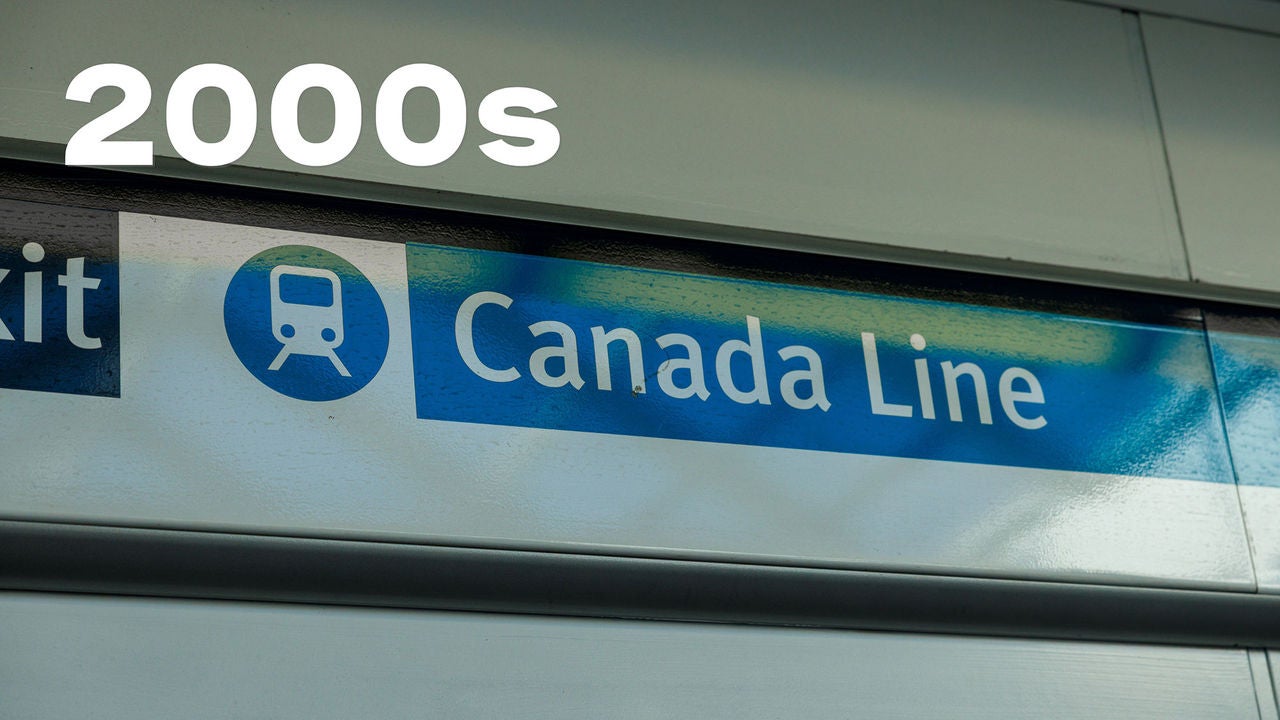 Signe bleu indiquant « Canada Line » avec une icône de train, indiquant un itinéraire de transit. Inscription « années 2000 » en caractères gras blancs au-dessus.