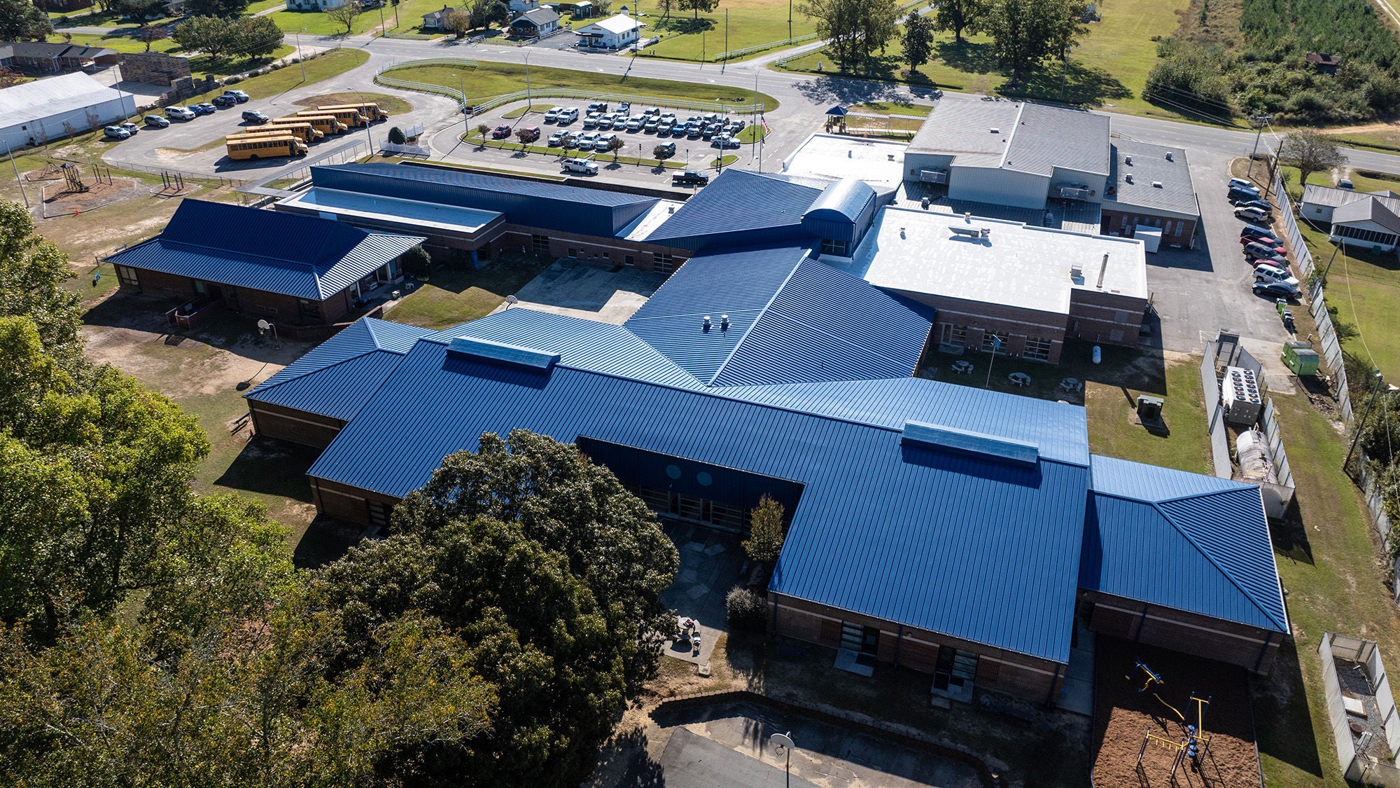 A blue metal roof of an elementary school, seen from directly above. 