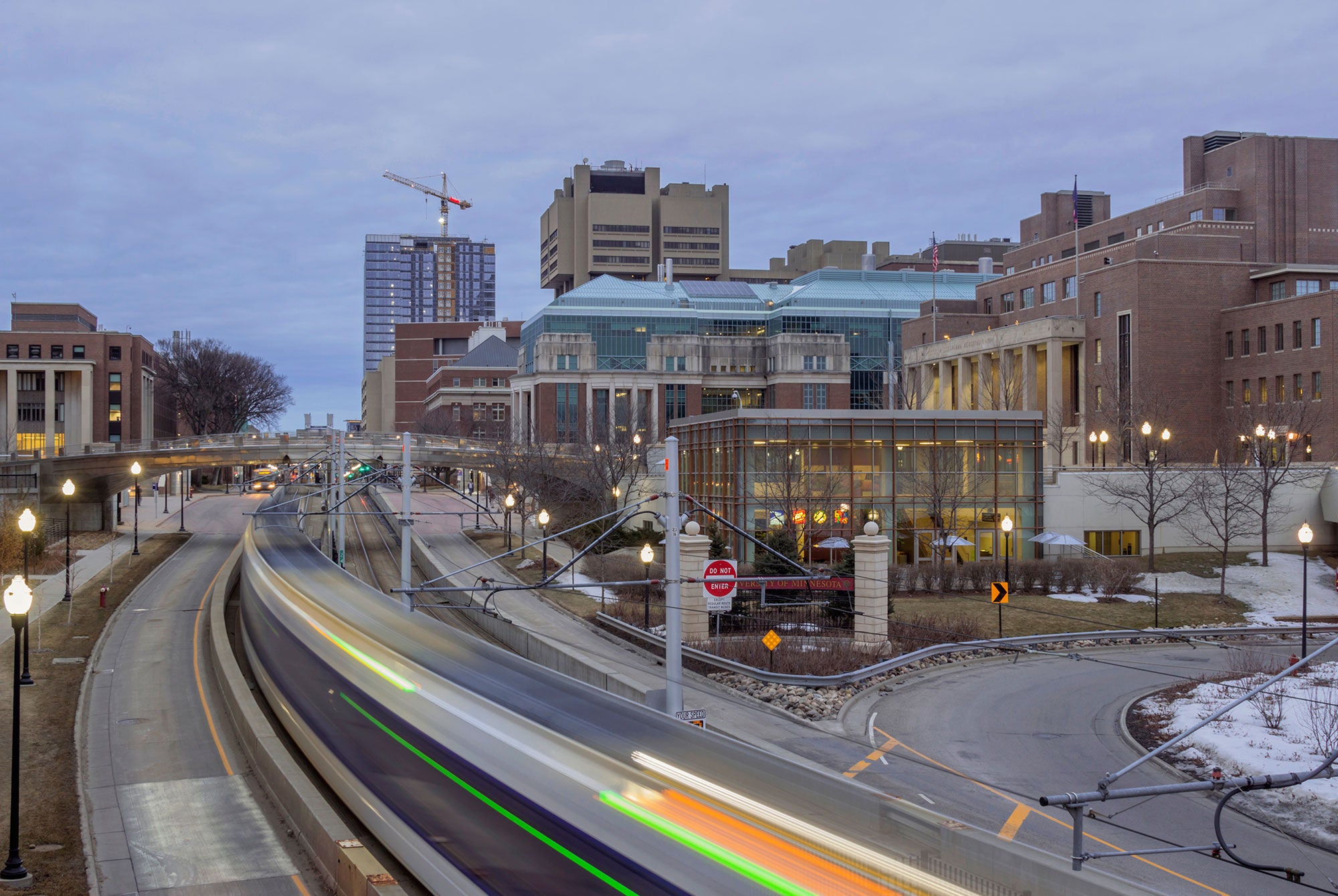 Wide angle of a light rail train passing through the University of Minnesota campus.