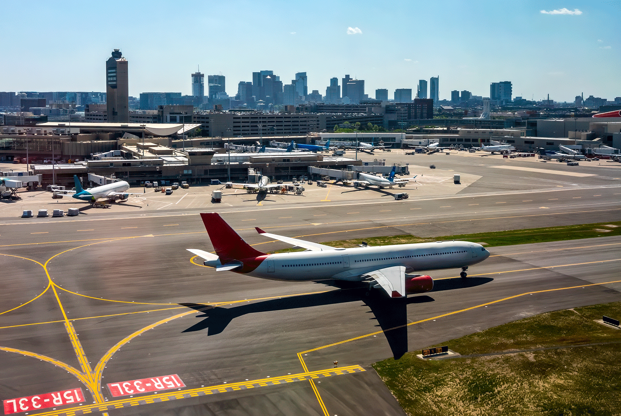 An airport in the foreground with a city skyline behind