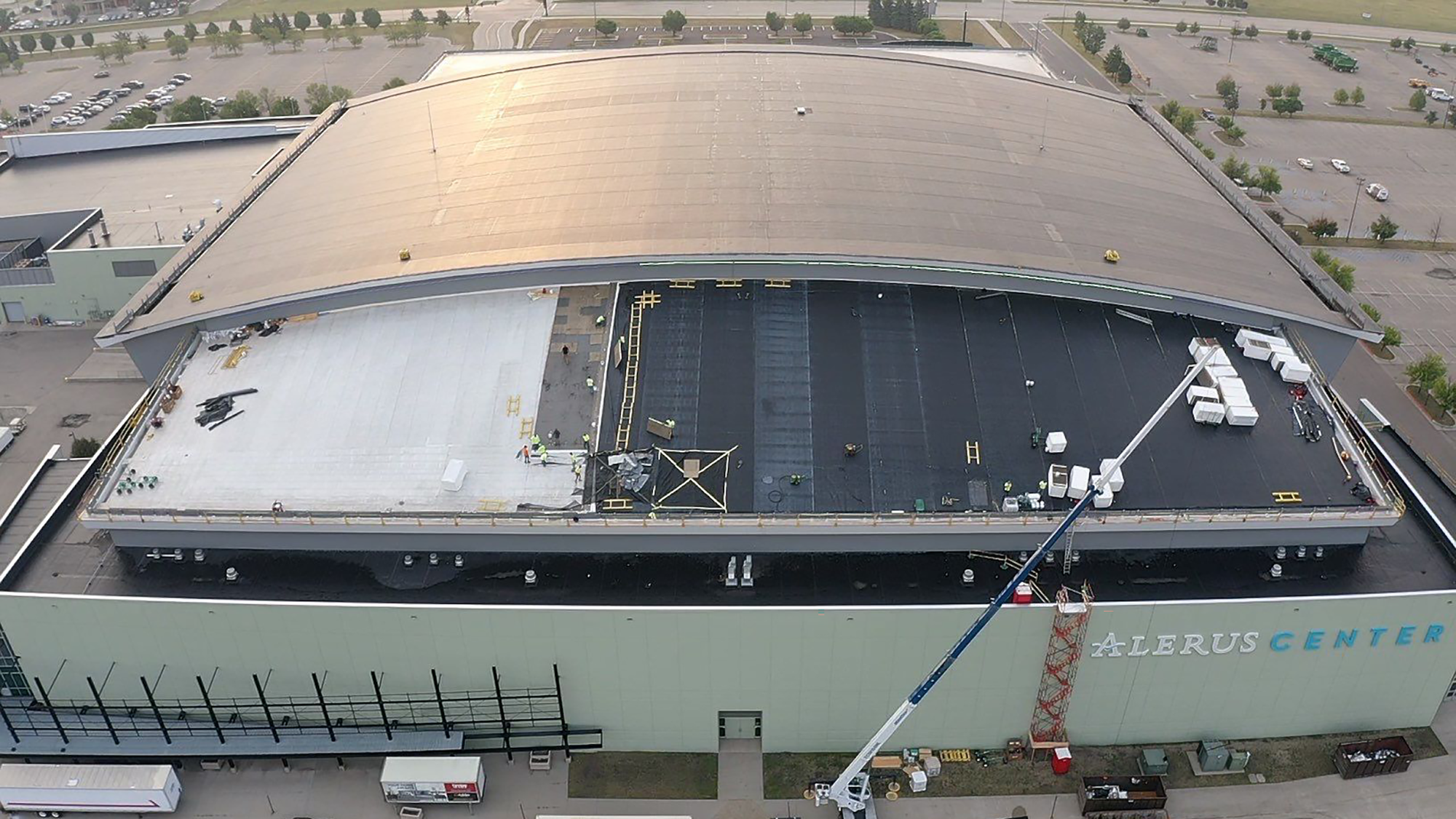A crane is parked in front of the Alerus Center entertainment venue as roofing work is underway
