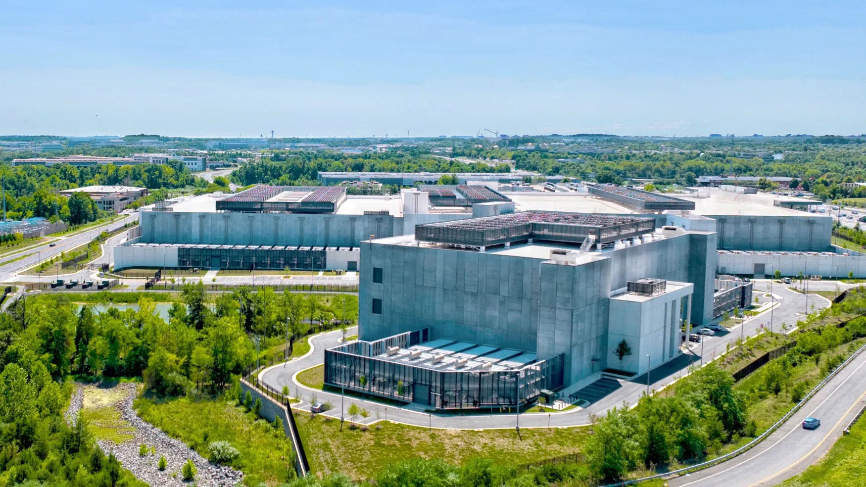 A campus of large commercial buildings set in a lush green landscape