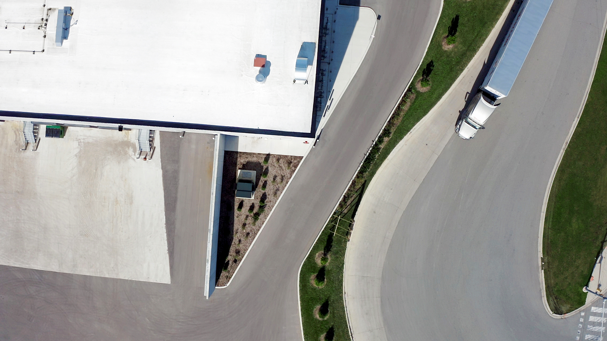 An aerial shot of a data center with a truck driving on a road beside it