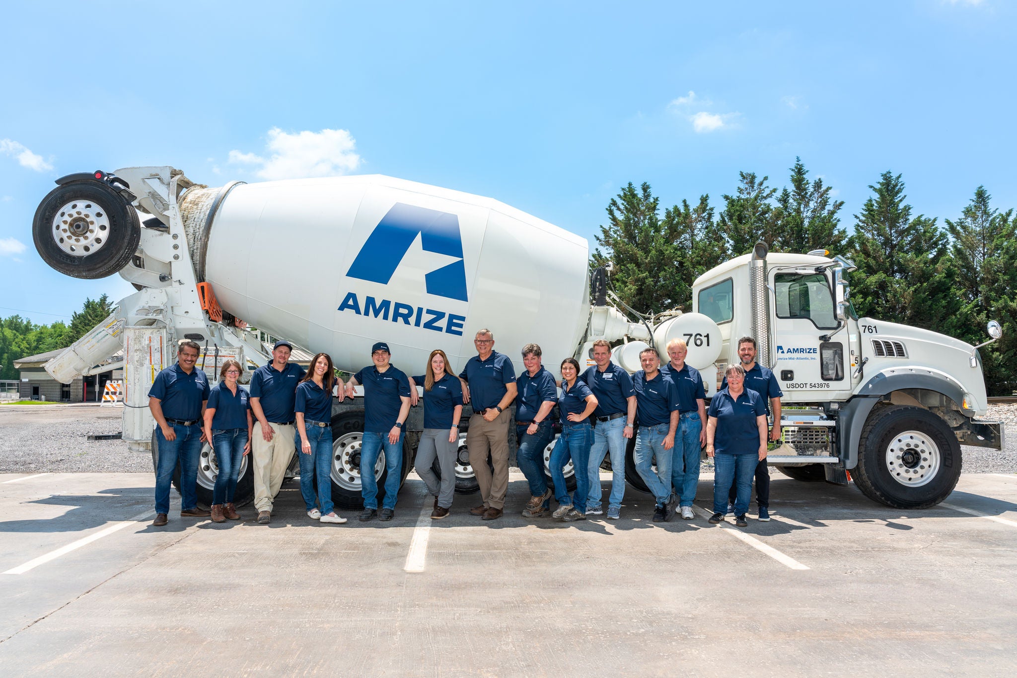 A group of employees gathered in front of a cement truck