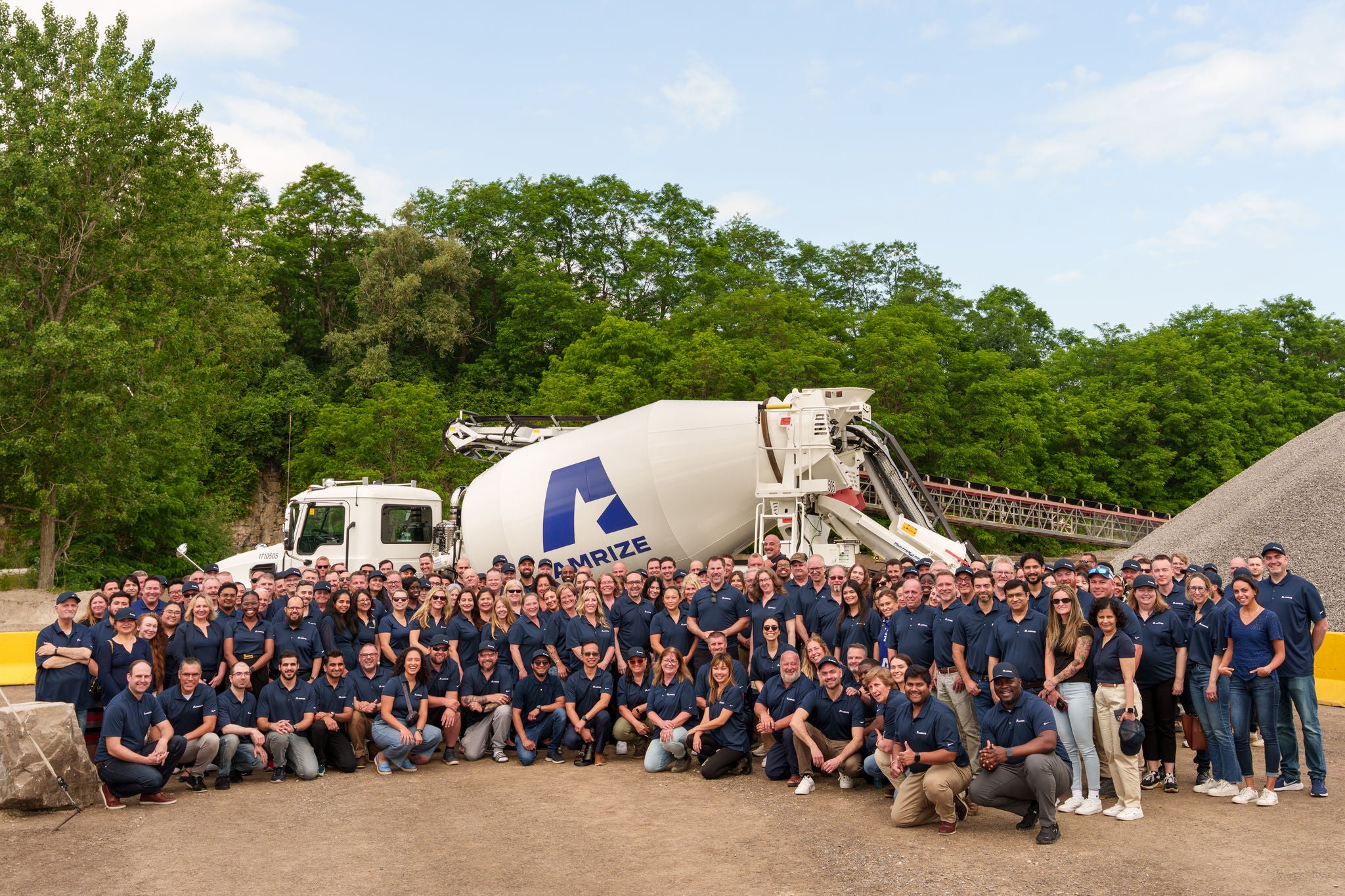 A large group of employees gathered around a cement truck
