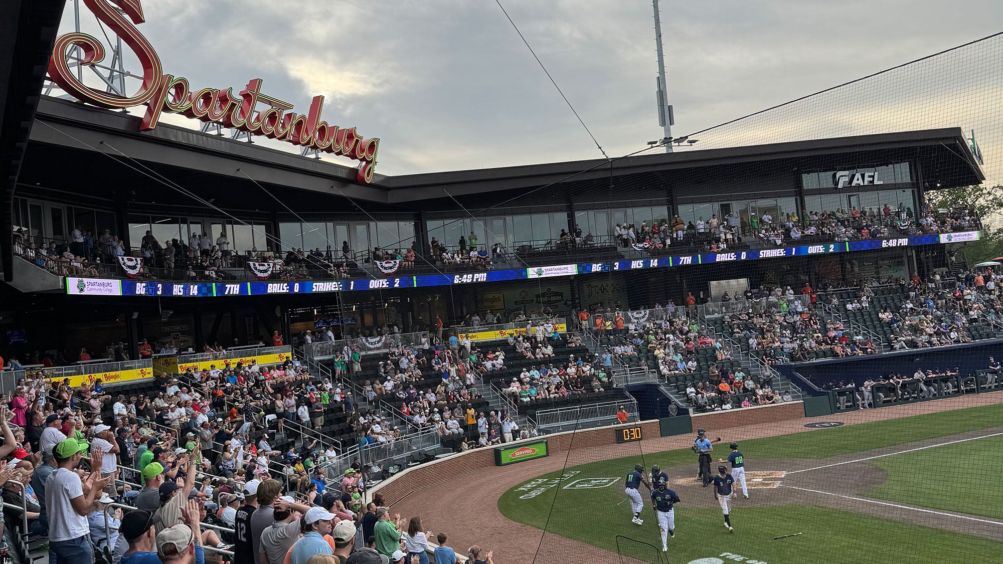 Fans packed in the stands of the baseball stadium during a game.