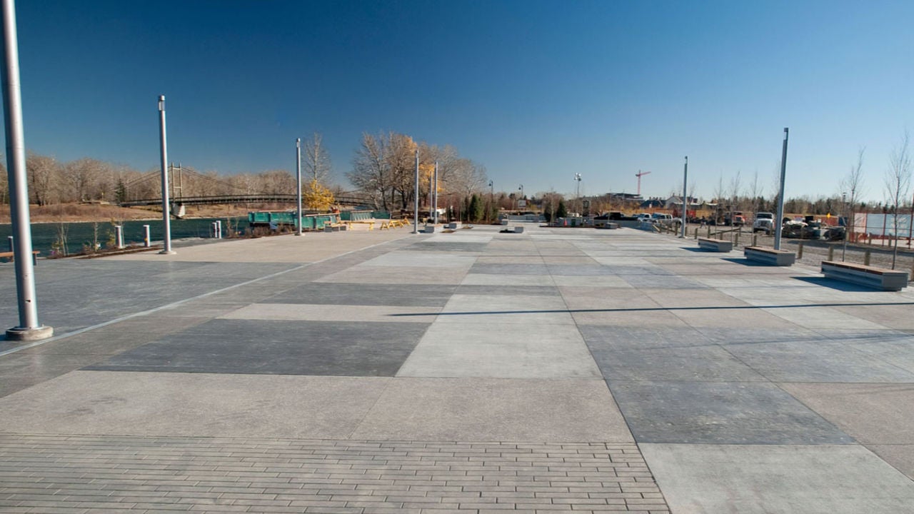 Modern geometric pavement patterns and minimalist lighting at the East Village RiverWalk Plaza.