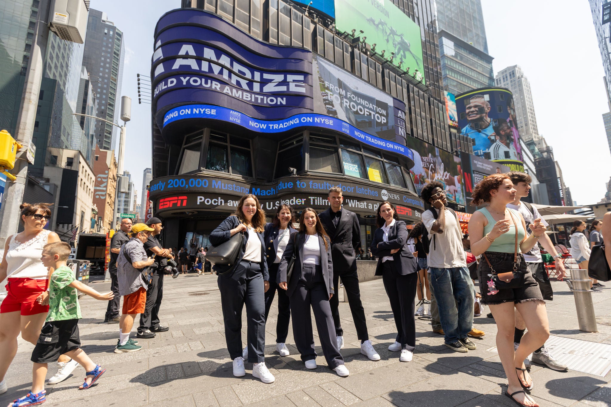 A group of employees celebrates in front of billboards in Times Square