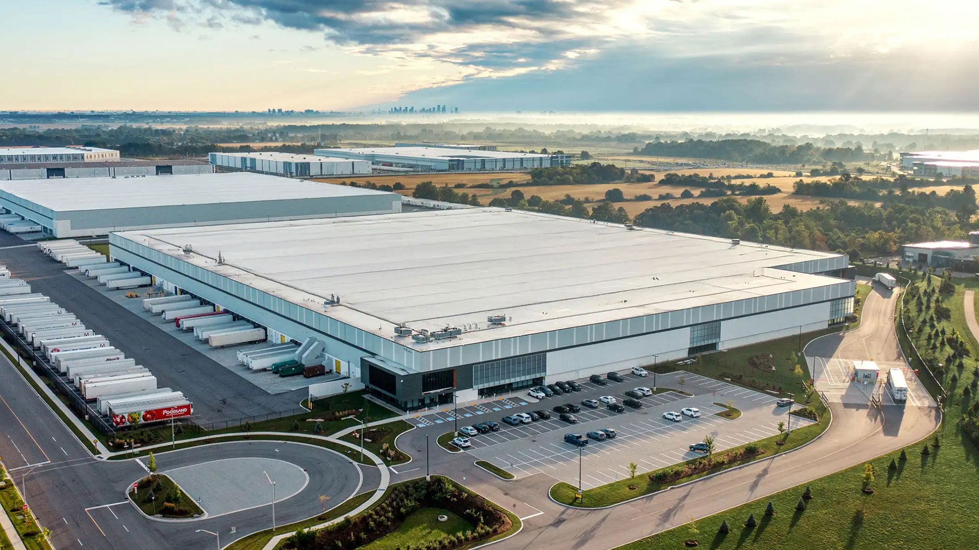 A large data center campus in a beautiful field landscape seen from the distance