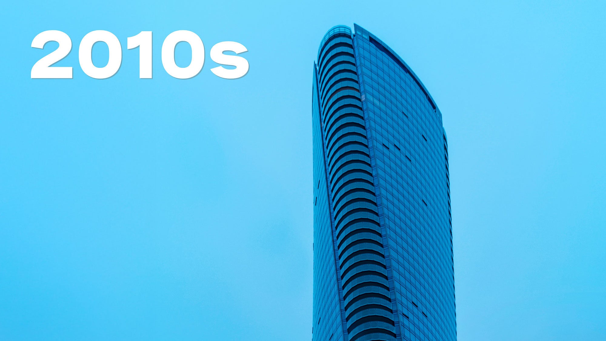 Le sommet torsadé d’un gratte-ciel moderne en verre et en béton dans le ciel crépusculaire.