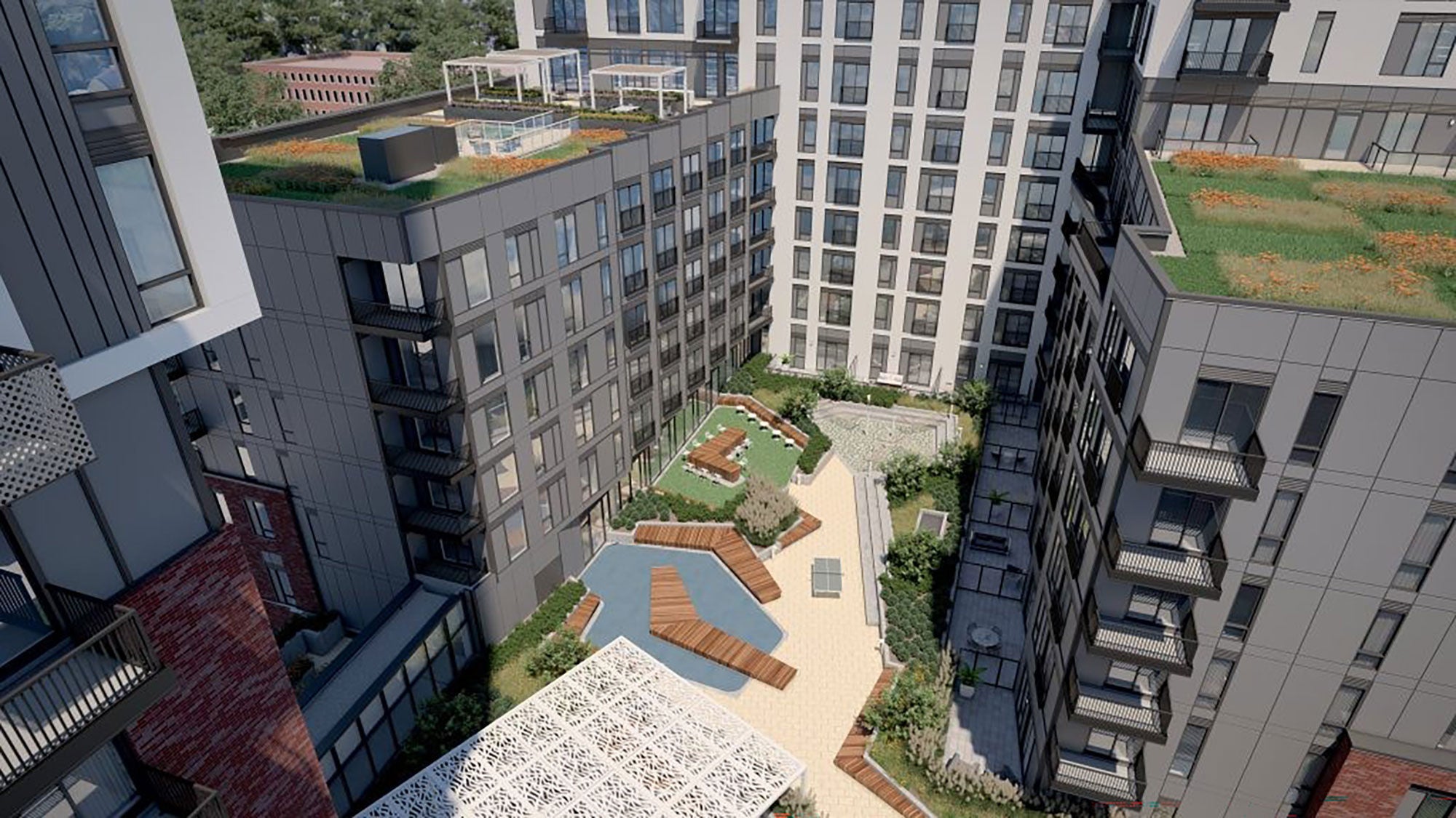 Aerial view of a modern apartment complex, Daniels on Parliament, featuring a courtyard with landscaped gardens, wooden seating, and rooftop greenery on a sunny day.