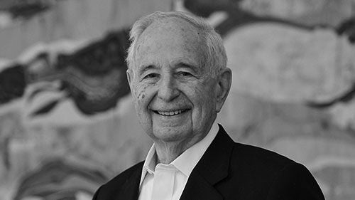 A black-and-white headshot of a gentleman in a suit