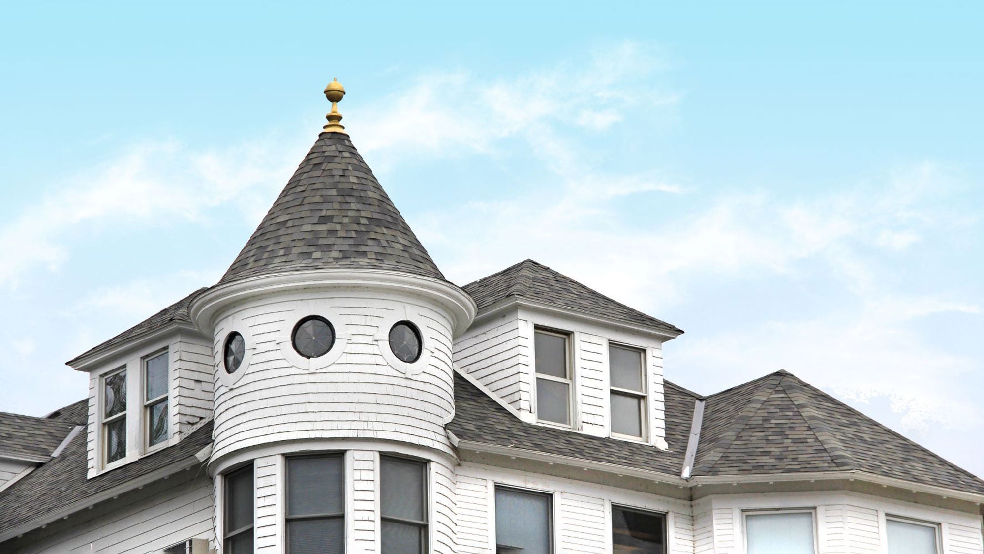  The roof of the Island House Hotel, a white building with shingles and a spiral roof structure.