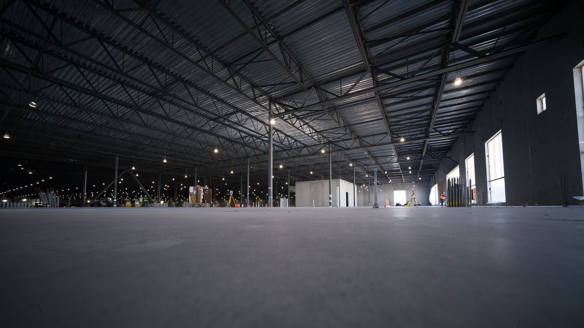 Large-scale Meta data center construction featuring a minimalist open floor plan and industrial lighting.