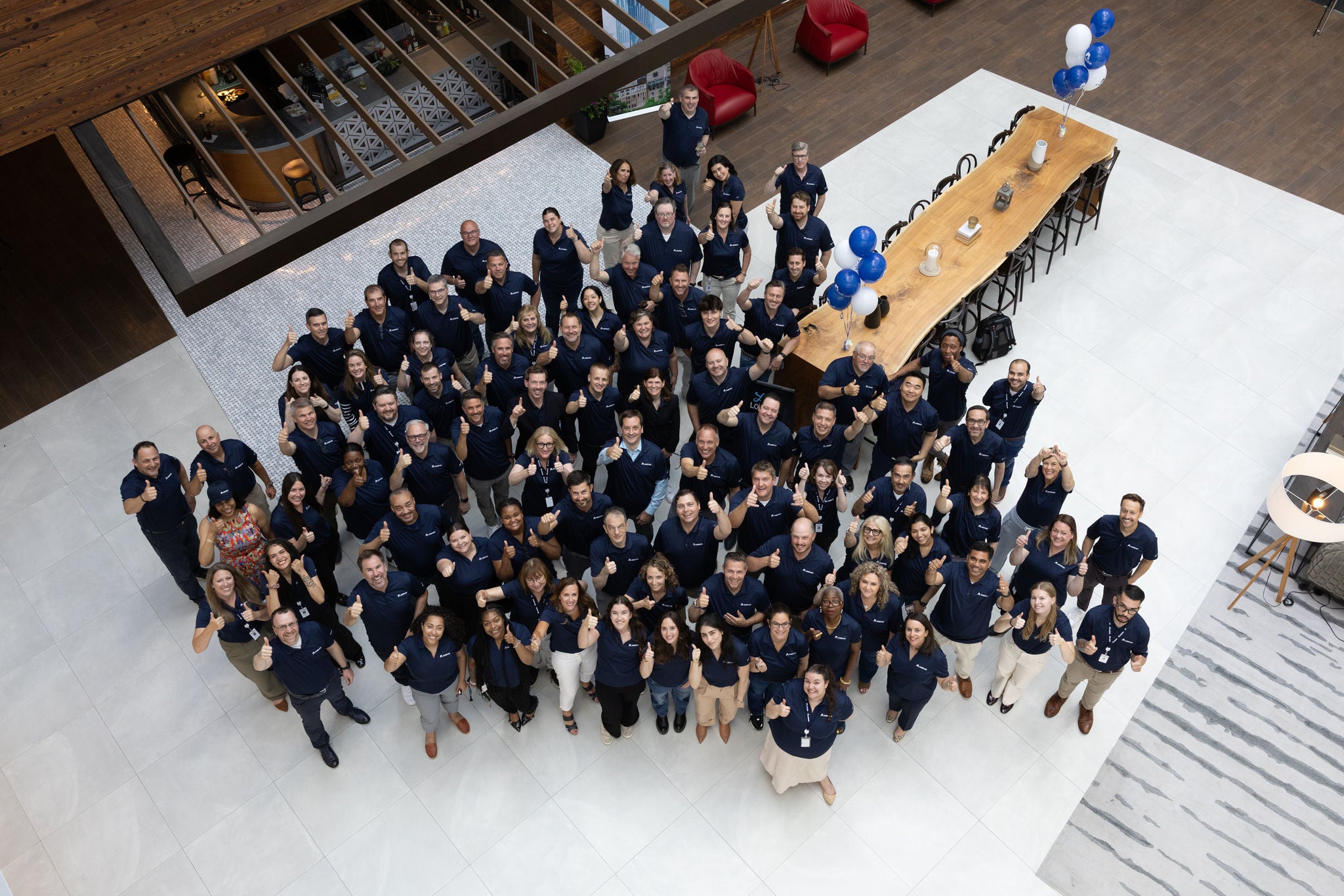 A large group of employees gathered in a building lobby