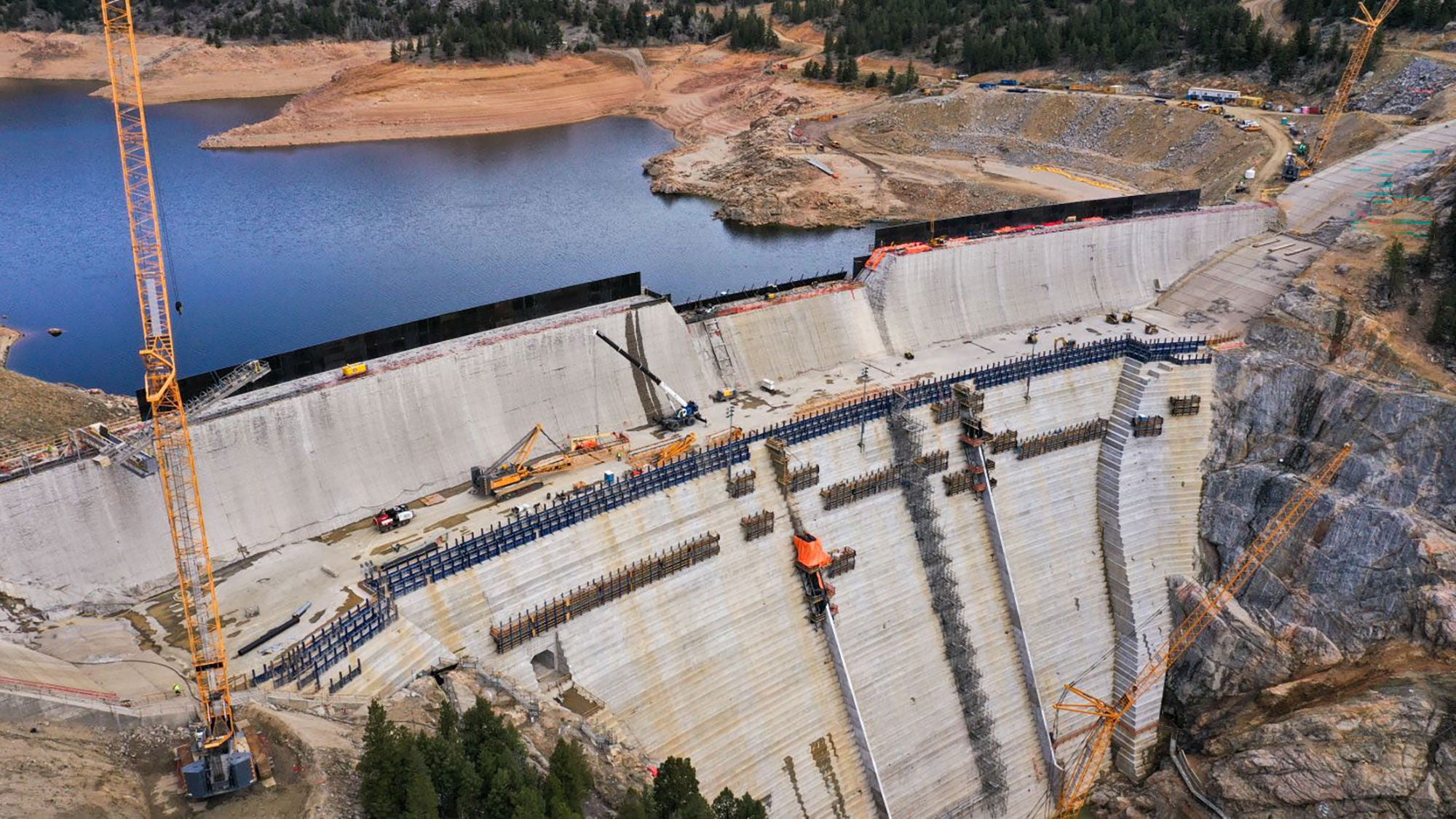 Aerial perspective of Gross Reservoir Dam expansion construction with the new, higher spillway under development. 