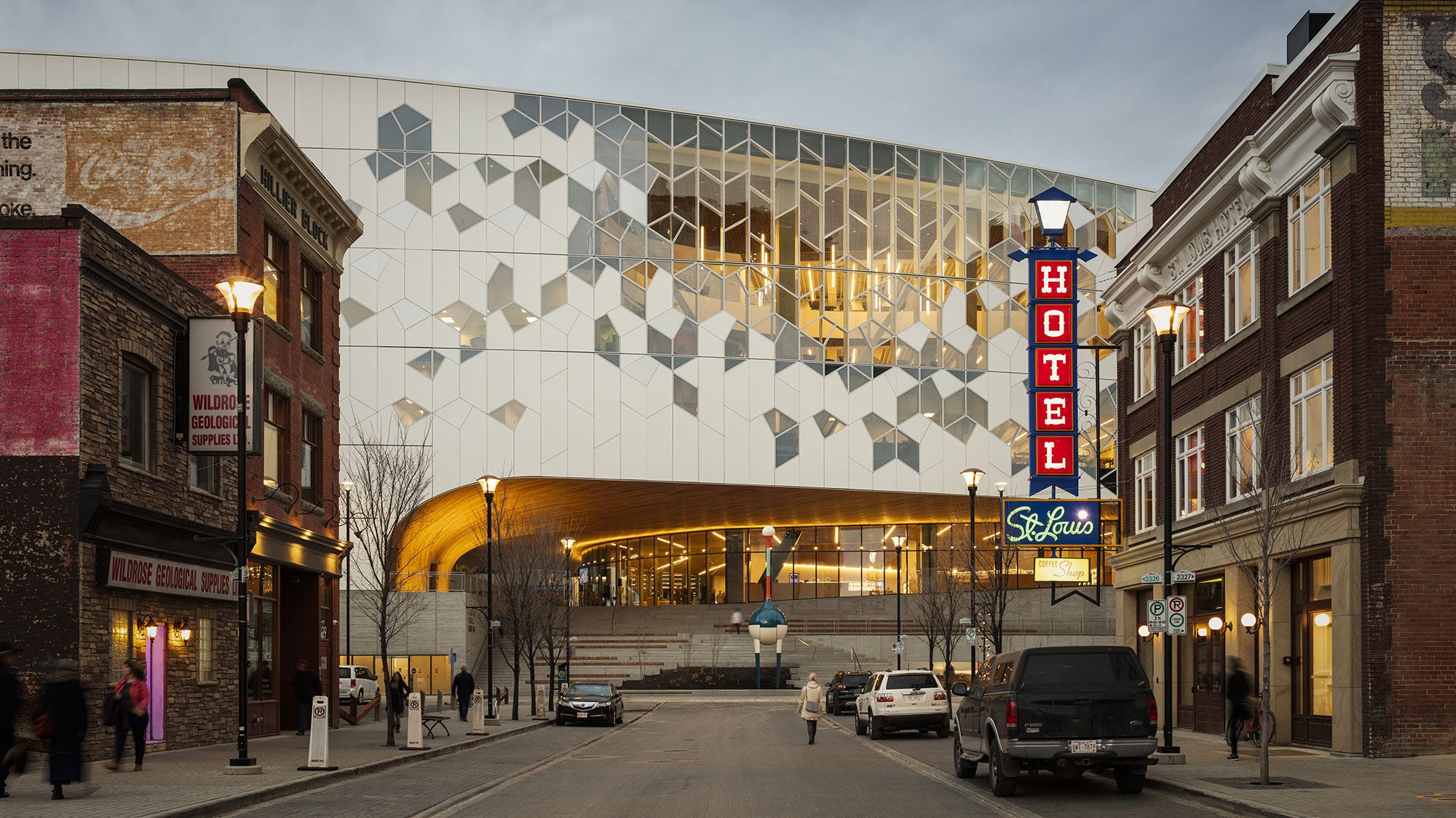 The Calgary Central Library entrance, showcasing Amrize precast concrete steps and landscape walls beneath an archway and geometric glass facade.
