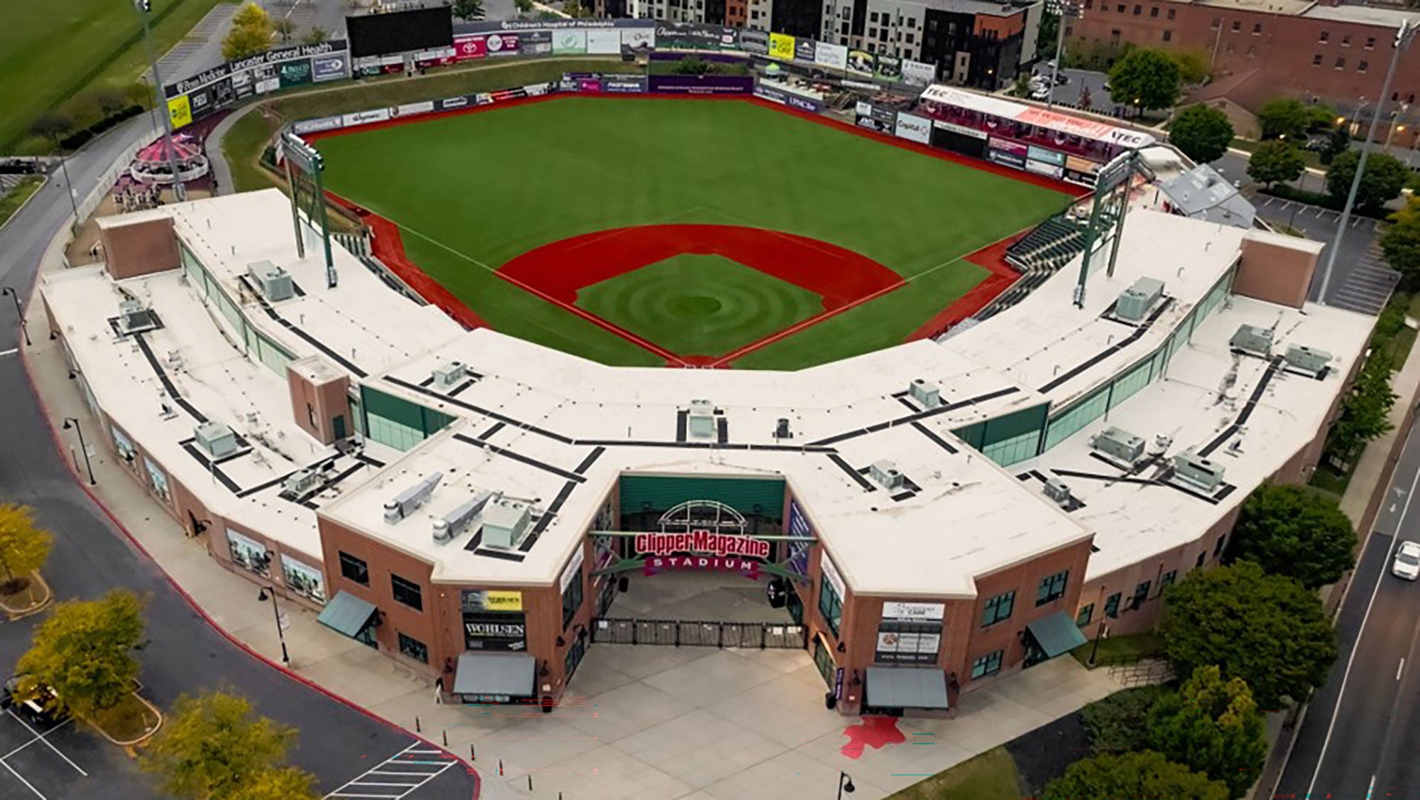 A baseball stadium, viewed from above, focusing on the white roof over the facility.