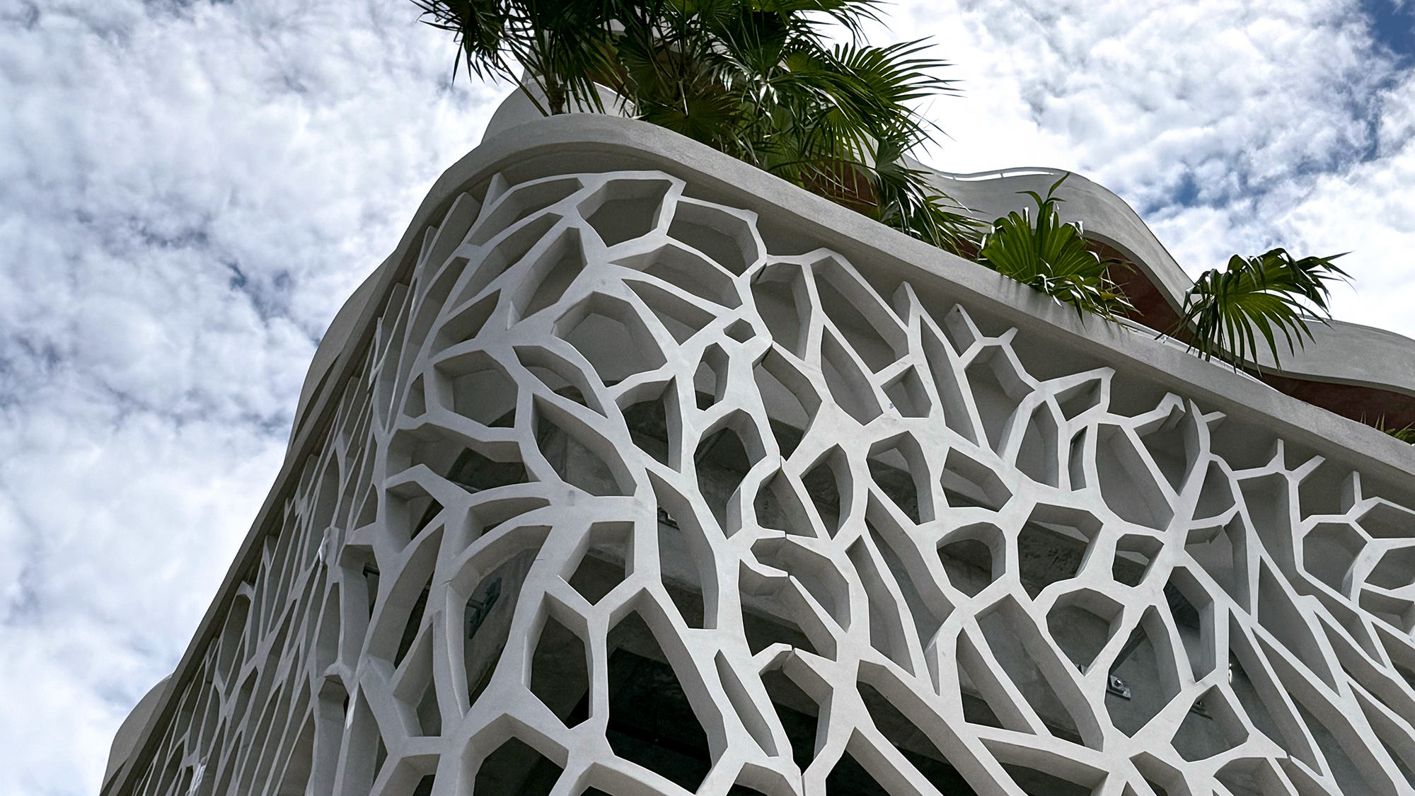 A closeup of a feature wall with wavy balconies above it.