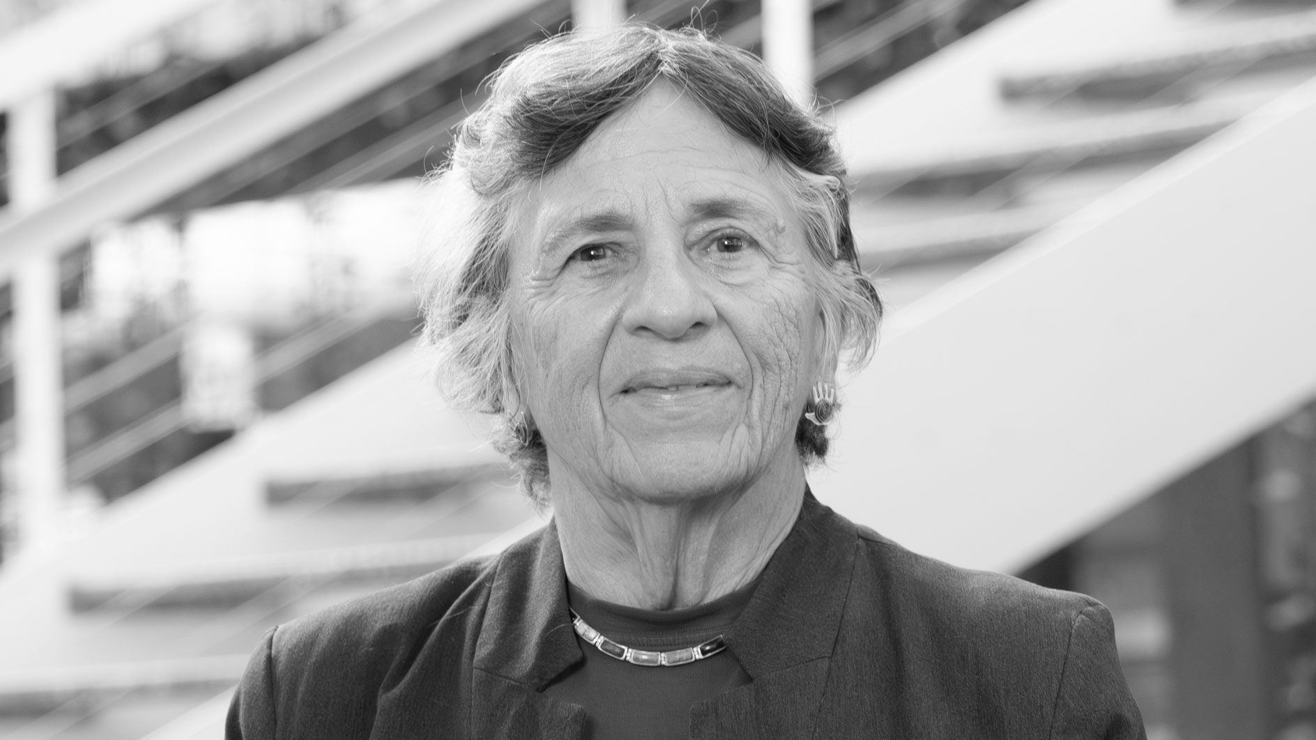 A black-and-white headshot of a woman with short hair