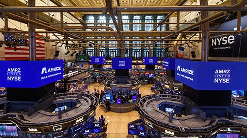 A large stock trading floor with kiosks and signs bearing the name "Amrize" on them