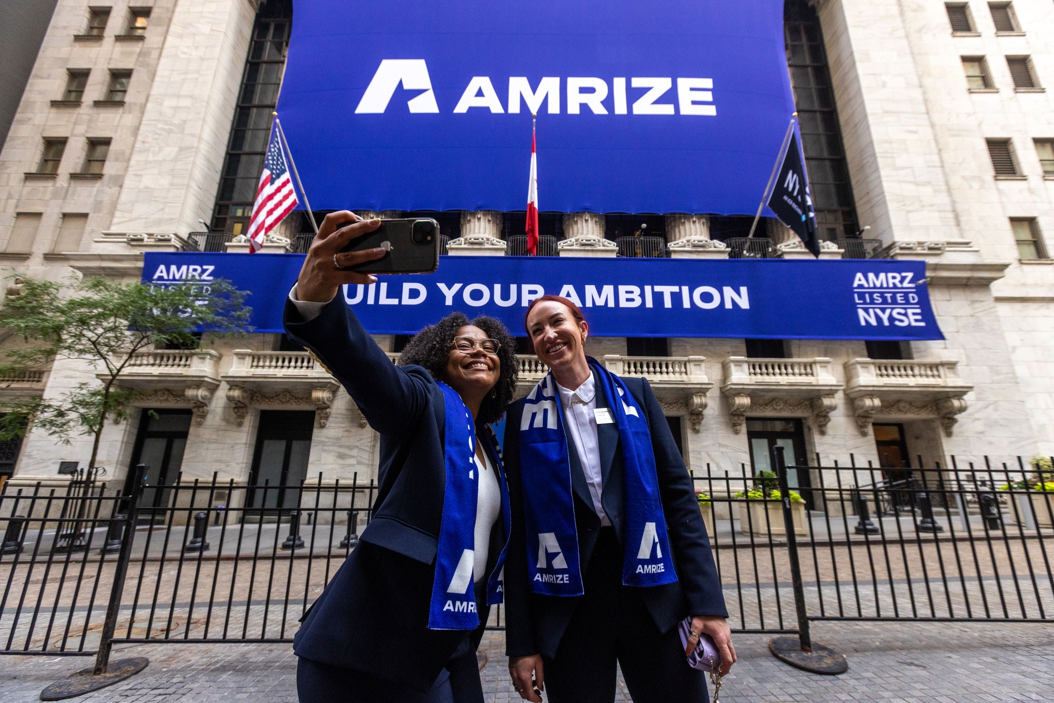Two employees celebrate in front of the NYSE building