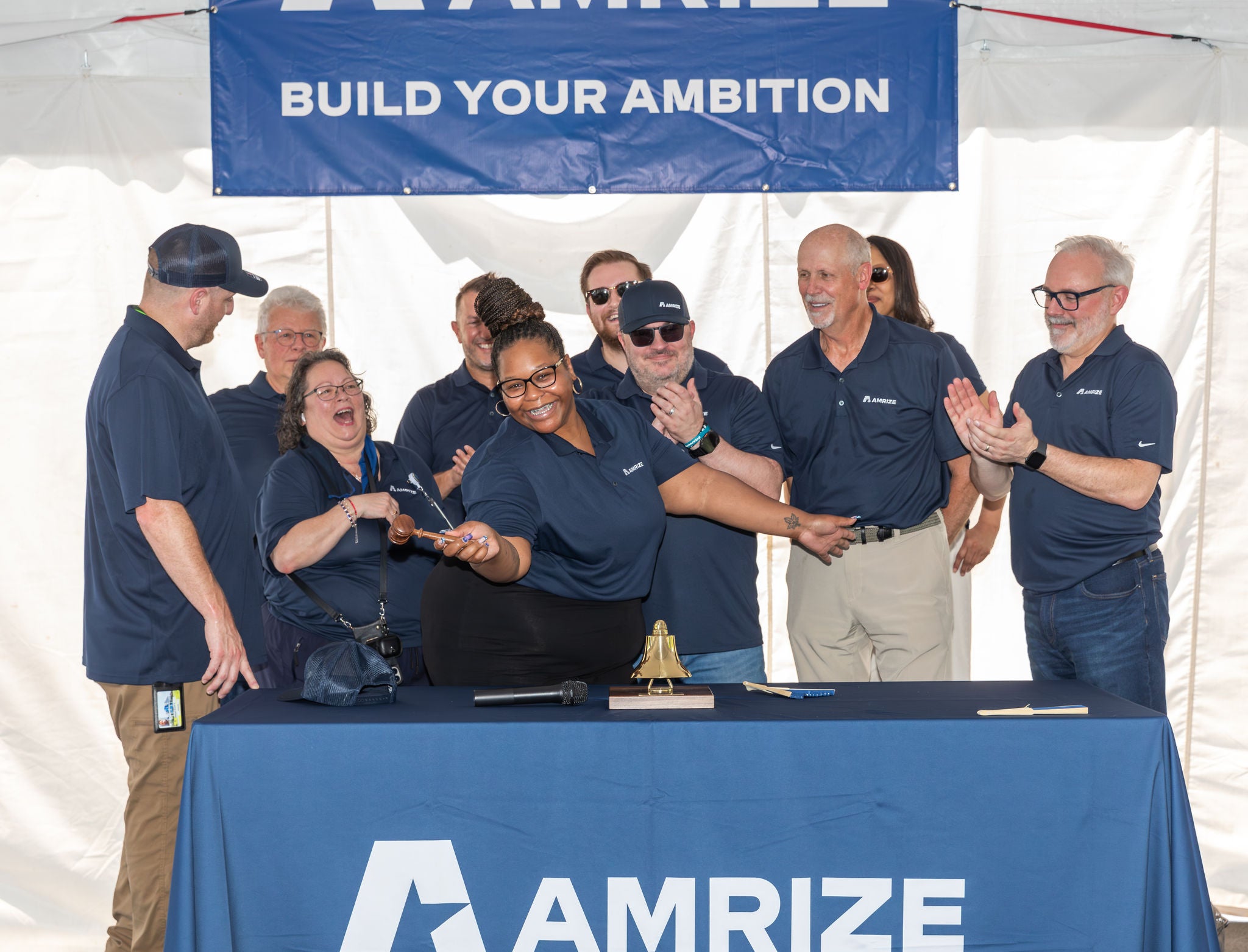 A group of employees celebrating at a podium