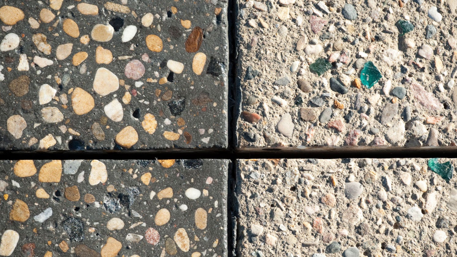 Macro view of four contrasting geometric concrete tiles with natural stone and green glass accents.