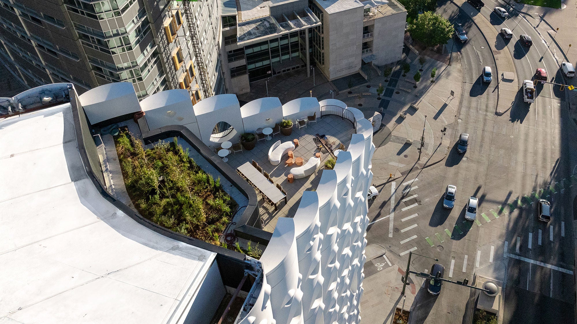 Aerial view of Populus’s rooftop terrace, with seating, a green roof, and Denver’s street grid below.