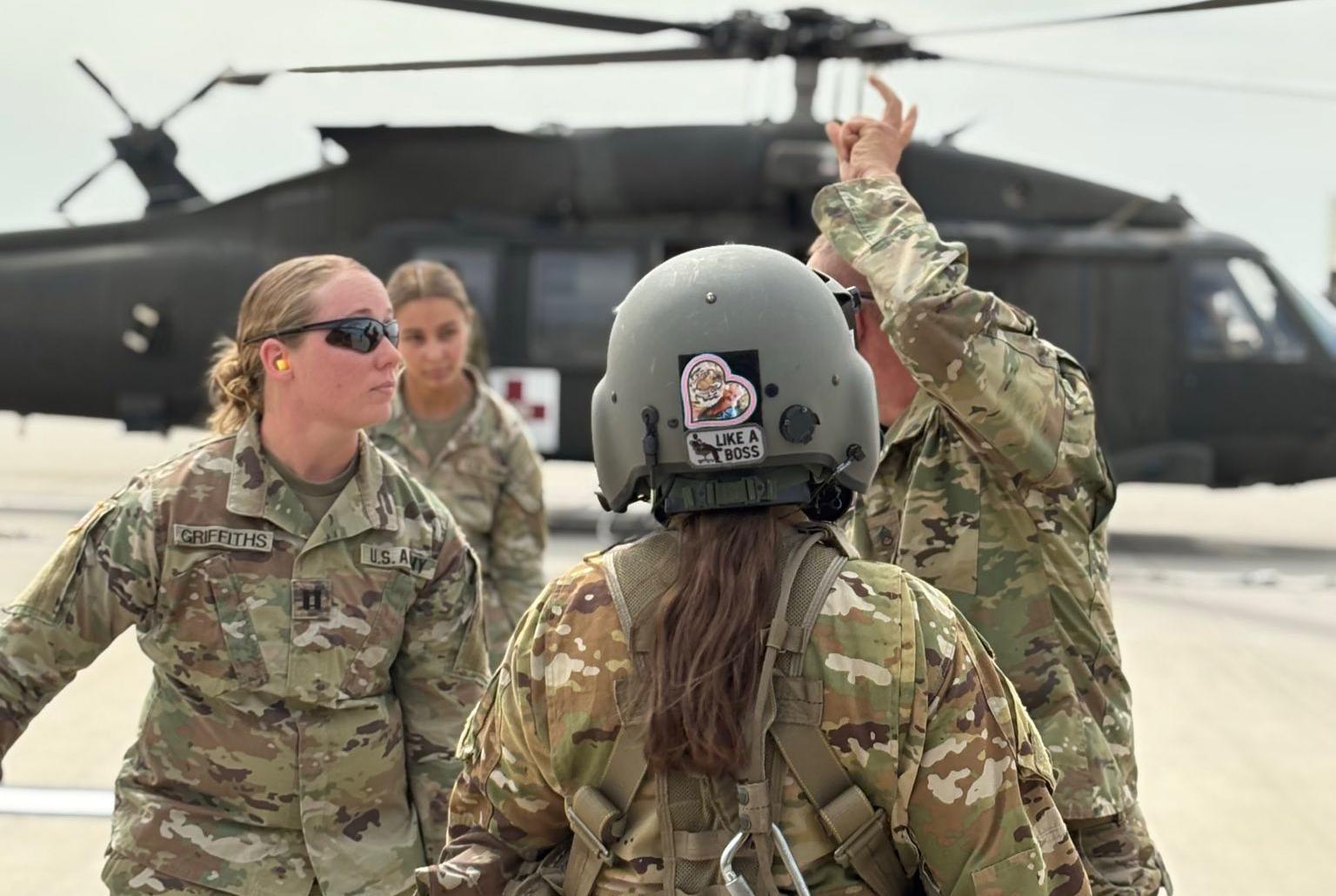Female soldiers listening to instructions in front of a helicopter