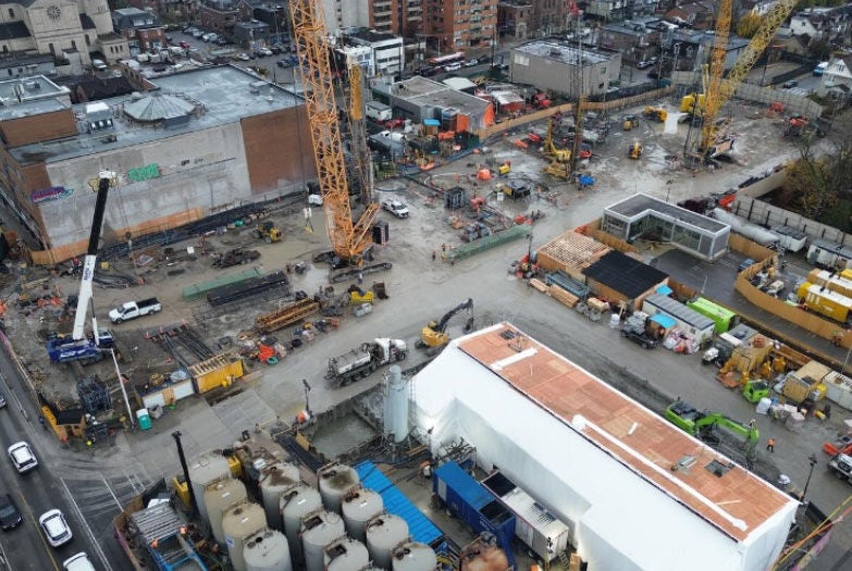 An aerial view of construction on a subway tunnel and underground station