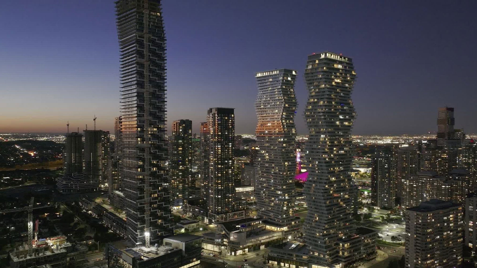 Mississauga skyline at night, featuring illuminated M City tall buildings against a dark sky.