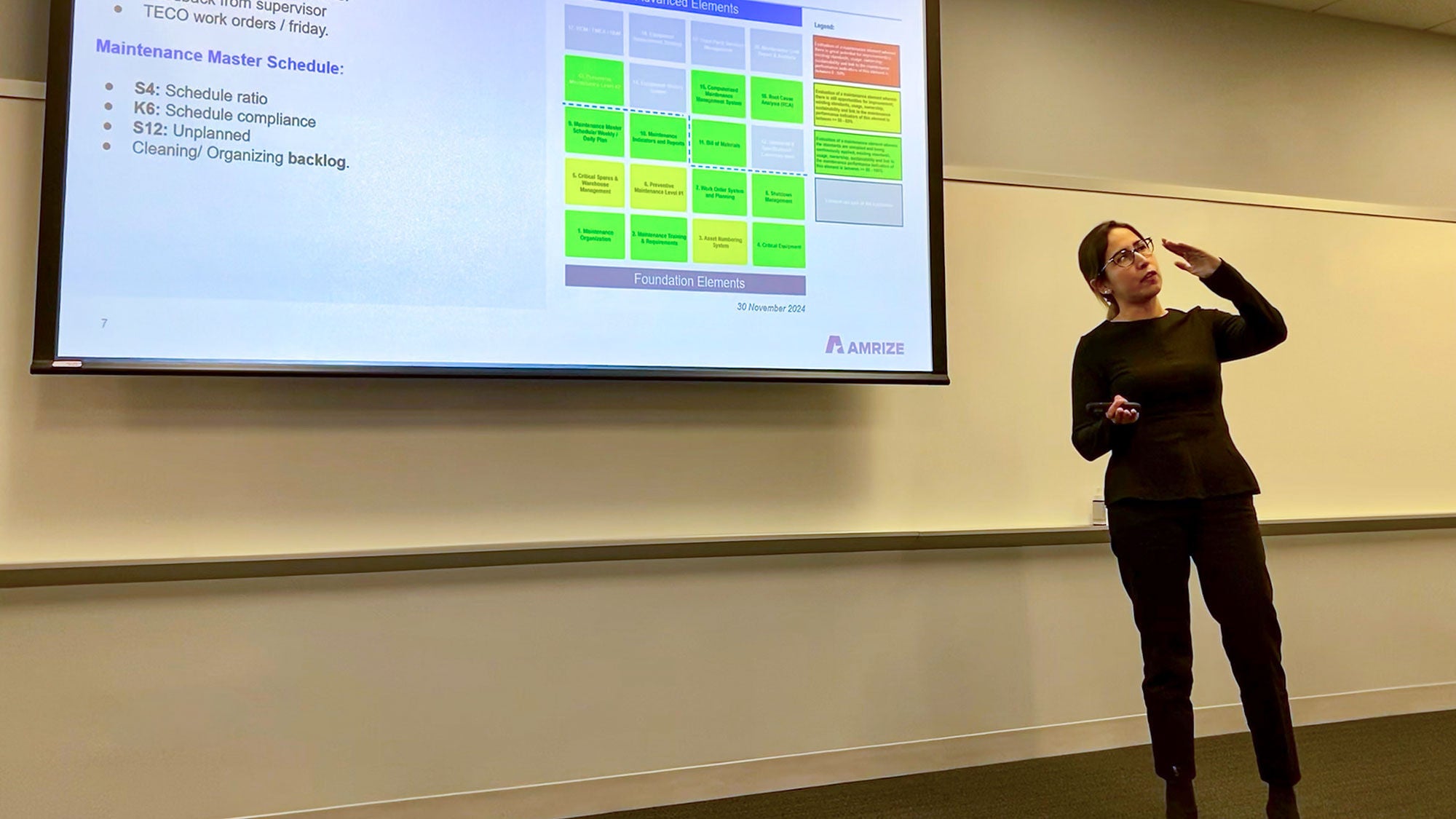 A professional woman giving a presentation on industrial maintenance, master information and foundation elements.