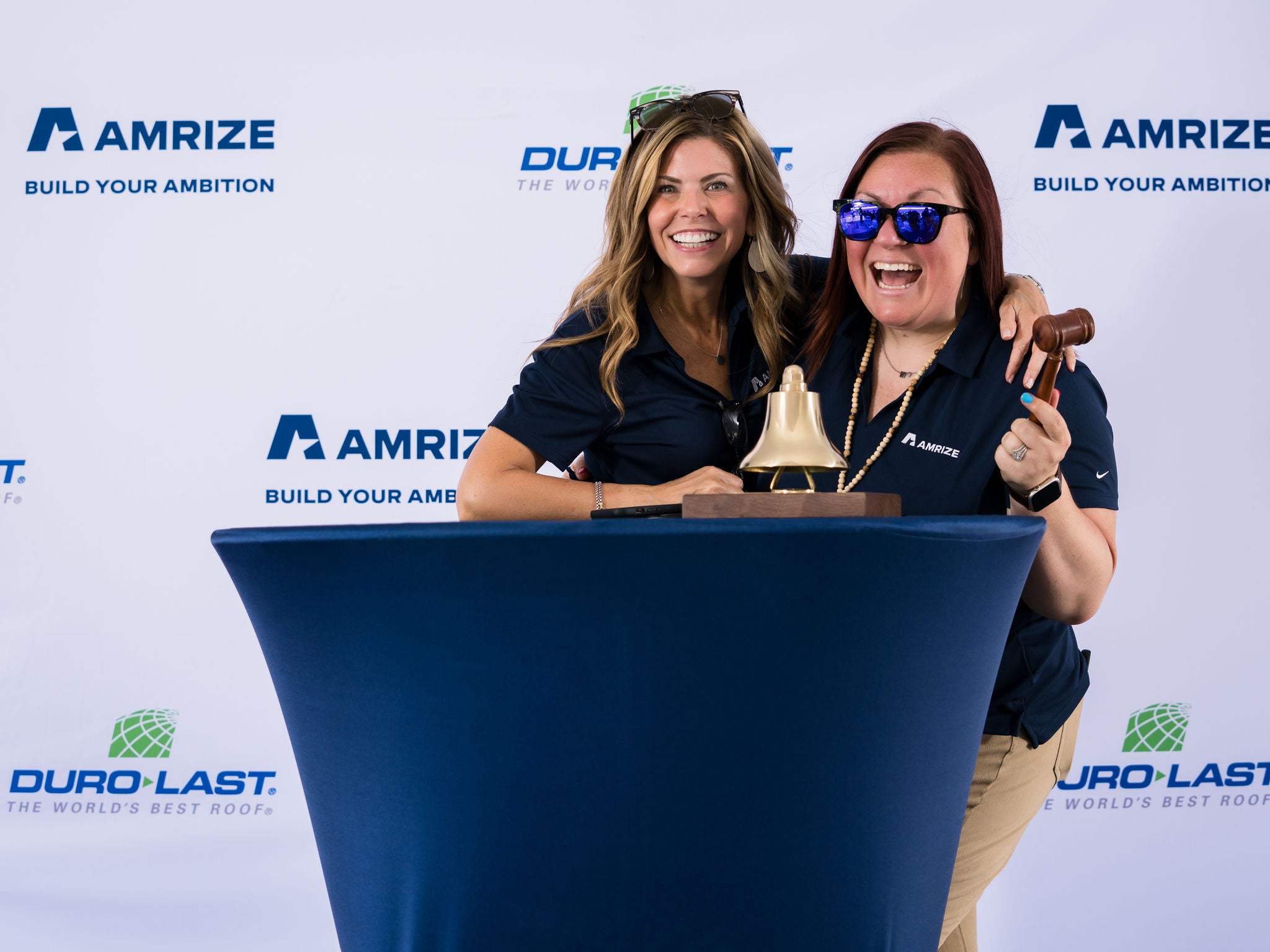 Two employees celebrating at a podium