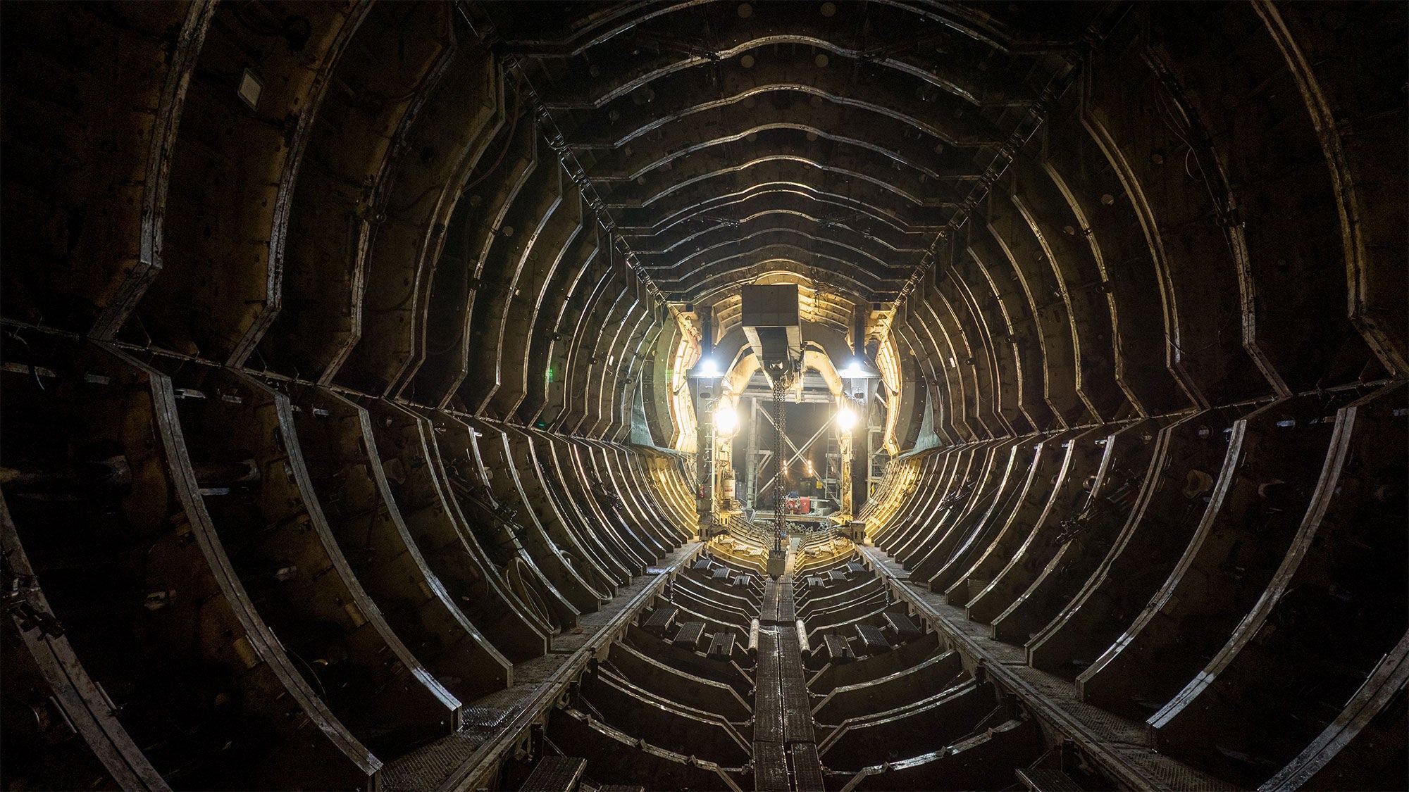Underground concrete casting site inside the Mill Creek Tunnel in Dallas, showing the industrial steel framework used to pour concrete walls.