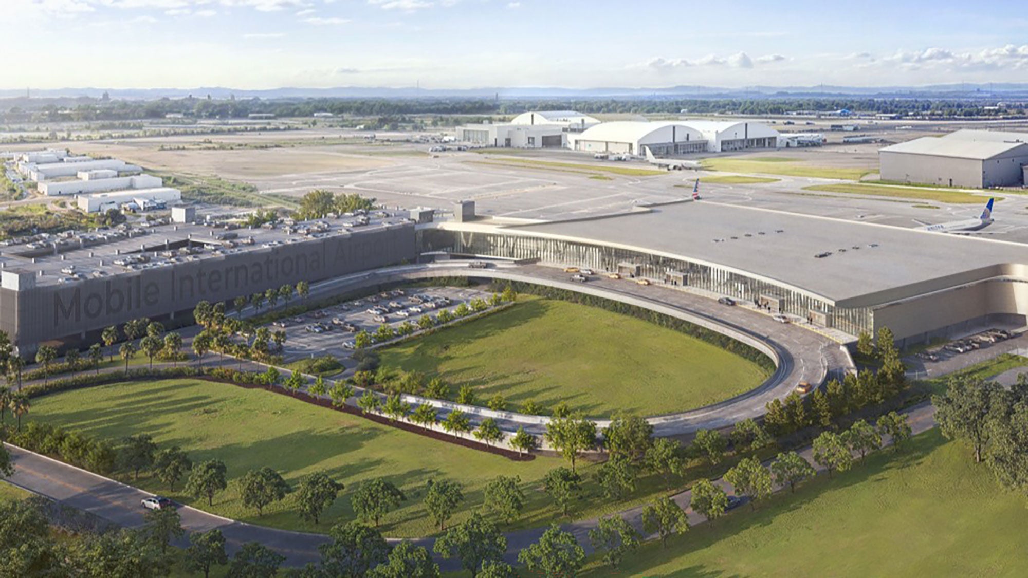 Aerial view of Mobile International Airport's terminal with a sleek design, surrounded by a curved road and greenery. Planes are parked at the gates, with a clear, sunny sky.