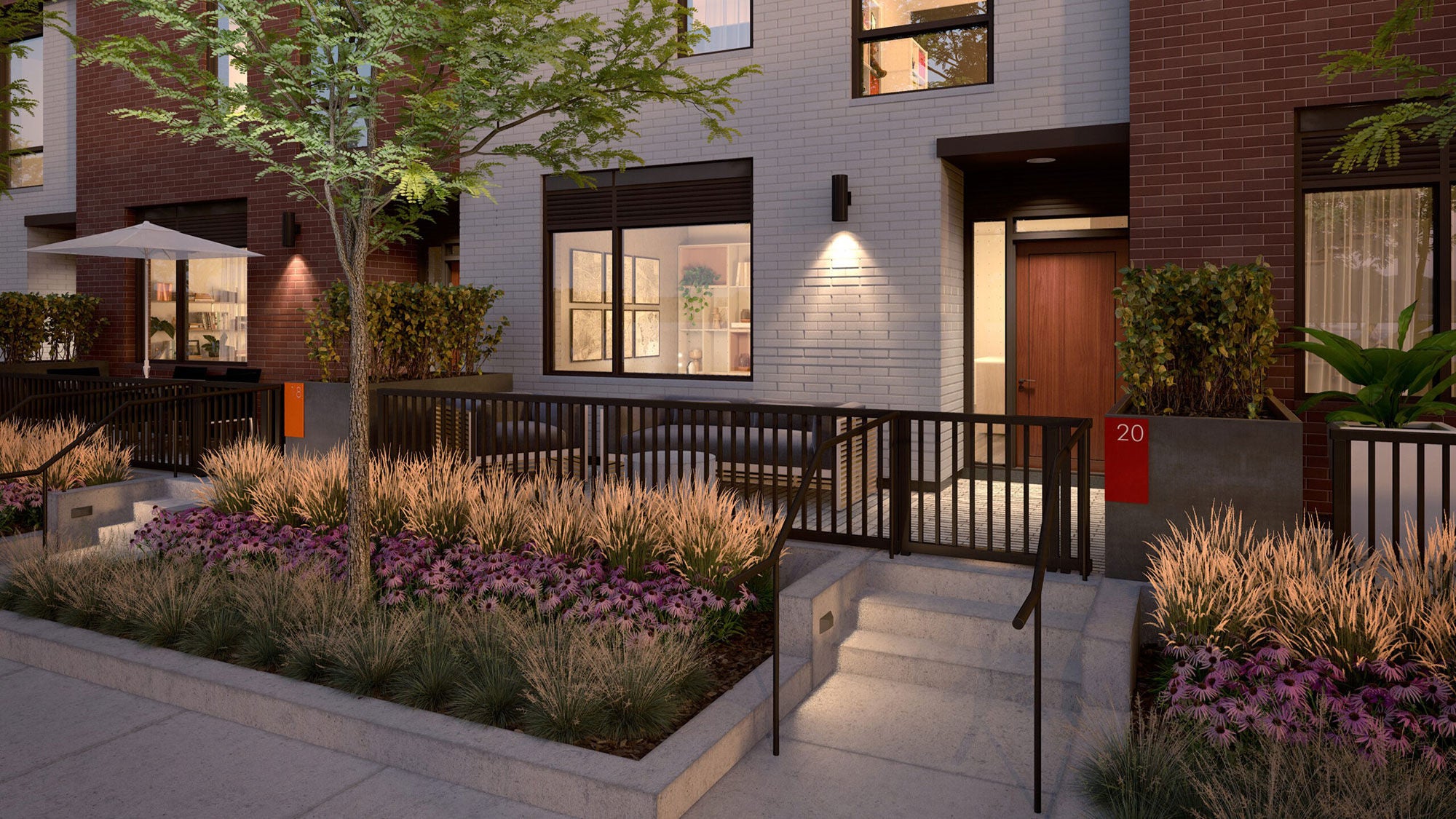 Daniels on Parliament modern residential entrance with a lit pathway, stairs, and railing. Lush greenery, vibrant purple flowers, and a tree share a space at the entrance.
